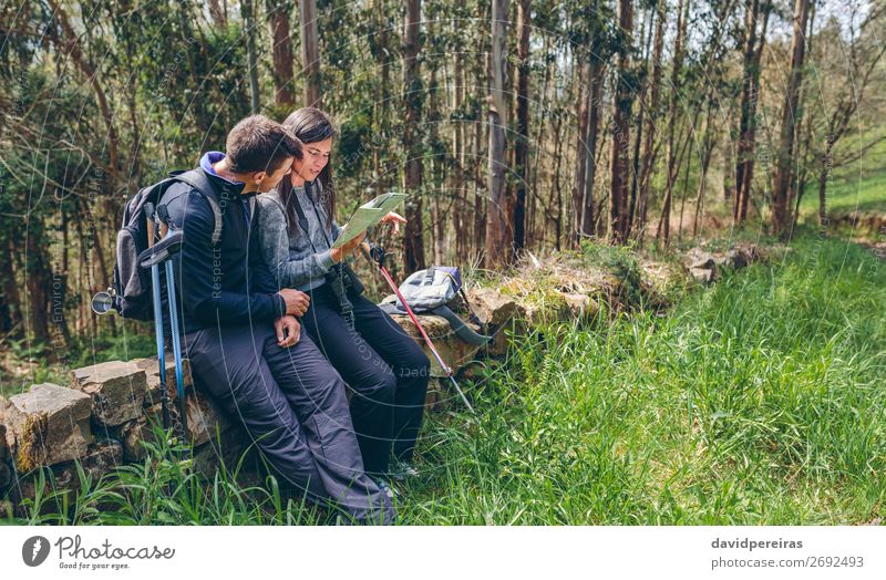 Couple doing trekking sitting looking at a map Leisure and hobbies Trip Adventure Sightseeing Mountain Hiking Sports Human being Woman Adults Man Nature