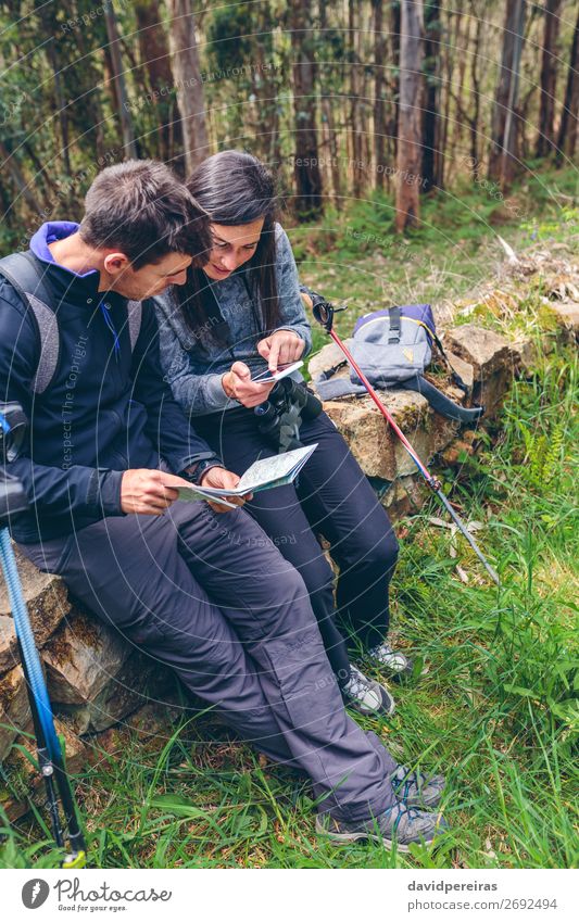 Couple doing trekking sitting looking mobile and map Trip Adventure Sightseeing Mountain Hiking Sports PDA Human being Woman Adults Man Nature Autumn Tree