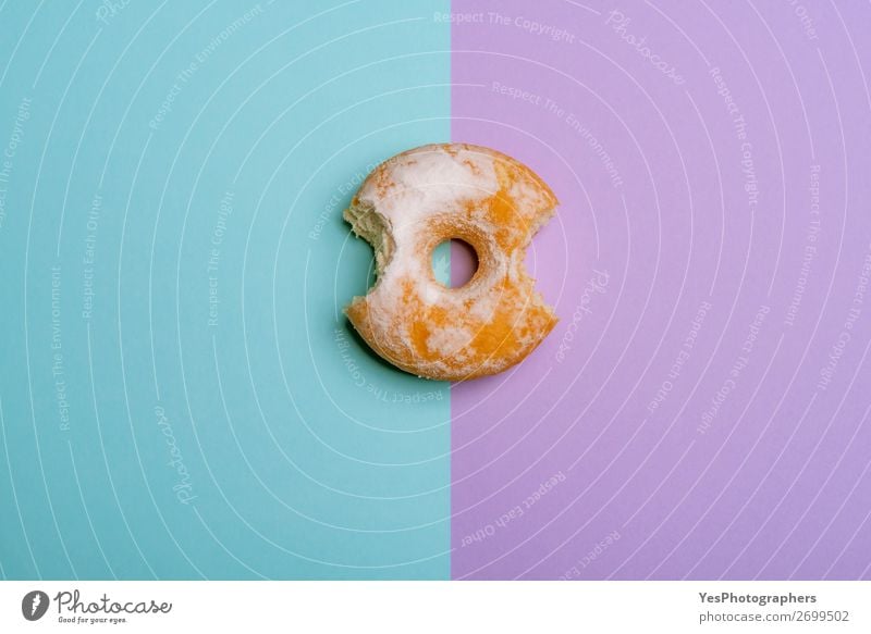 Bitten donut on blue-violet bicolored background Dessert Breakfast Blue Pink above view Baking Bakery bite bitten cake Confectionary Copy Space Donut Eaten