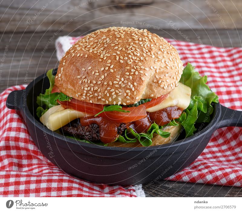 burger with a meatball and vegetables Meat Cheese Vegetable Bread Roll Lunch Dinner Fast food Pan Table Wood Eating Fresh Large Delicious Green Red Black