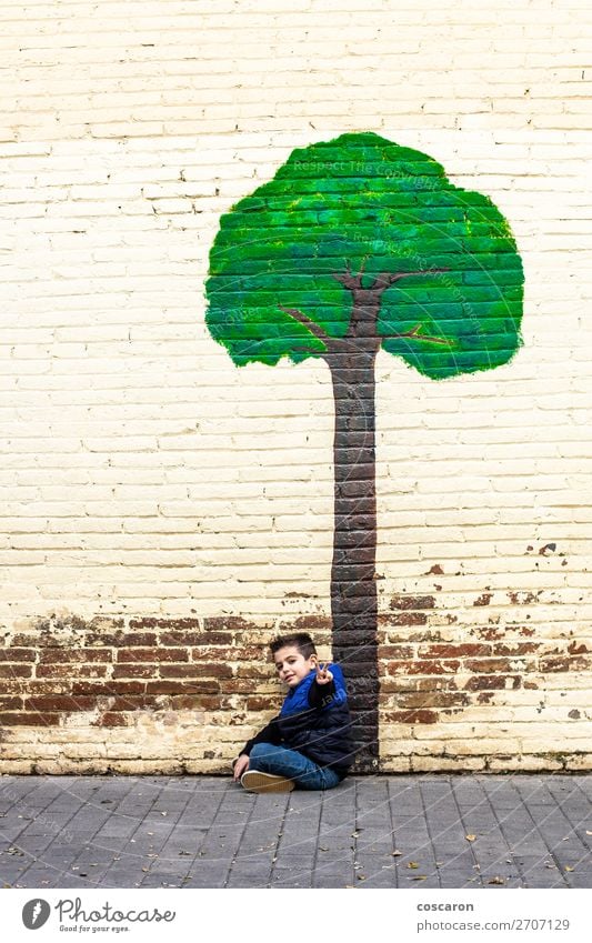 Little kid seated under a tree painted on a wall Lifestyle Design Joy Happy Beautiful Playing Vacation & Travel Adventure Winter Garden House building Climbing