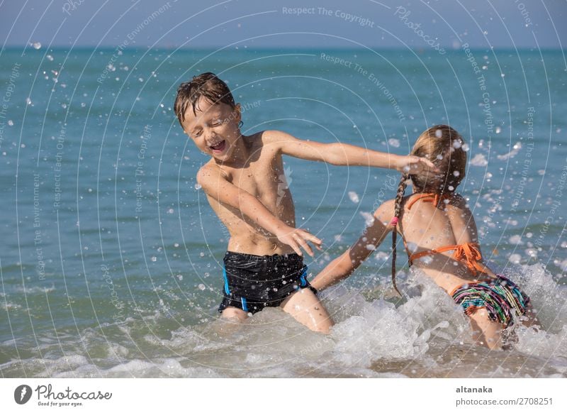 Happy children playing on the beach at the day time. Two Kids having fun outdoors. Concept of summer vacation and friendly family. Lifestyle Joy Beautiful