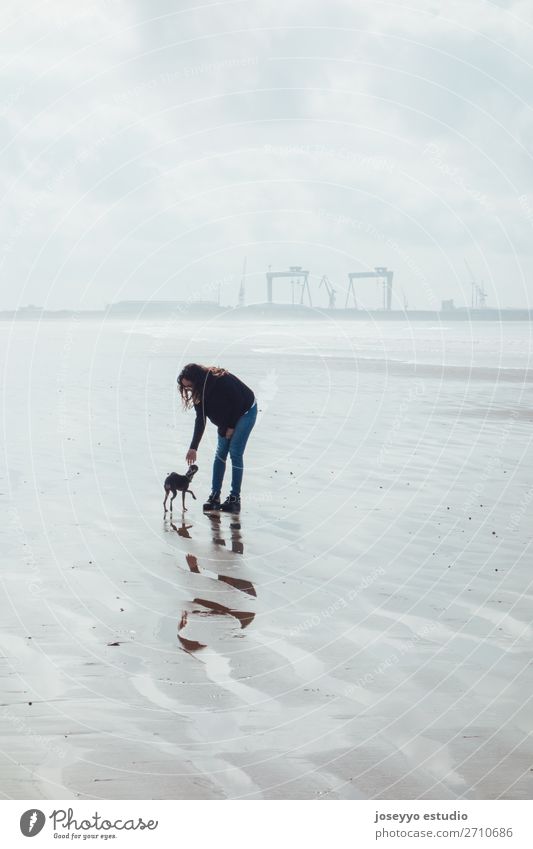 Woman and her small dog on the beach Lifestyle Relaxation Beach Winter Adults Friendship Nature Landscape Sand Sky Horizon Skyline Bridge Jeans Brunette Dog