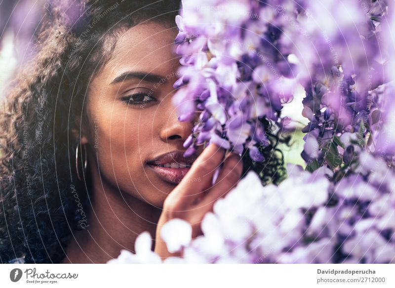 Thoughtful happy young black woman surrounded by flowers Woman Blossom Spring Lilac Close-up multiethnic Black African Mixed race ethnicity To enjoy Happy