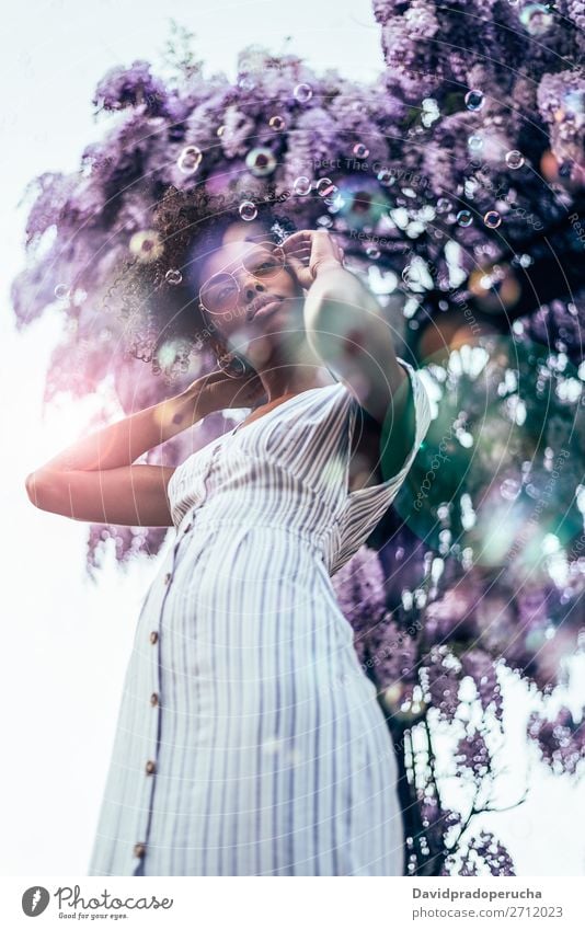 Happy young black woman surrounded by flowers Woman Blossom Spring Lilac Portrait photograph multiethnic Flower Black African Mixed race ethnicity Smiling