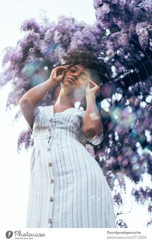 Happy young black woman surrounded by flowers Woman Blossom Spring Lilac Portrait photograph multiethnic Flower Black African Mixed race ethnicity Smiling