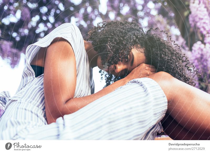 Young sad black woman sitting surrounded by flowers Woman Blossom Considerate Spring Lilac Portrait photograph multiethnic Black African Mixed race ethnicity