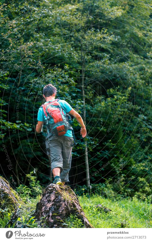 Young wanderer with backpack walking over a rock towards forest Lifestyle Leisure and hobbies Tourism Adventure Summer Hiking Human being Boy (child) Man Adults