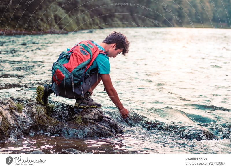 Young boy with backpack sitting on rock over a river Lifestyle Body Leisure and hobbies Vacation & Travel Trip Summer Human being Boy (child) Young man