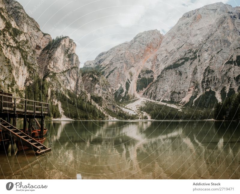 Wooden dock on lake in mountains Dock Mountain Lake Jetty Serene House (Residential Structure) Calm Water Tree Landscape Reflection coniferous Exterior shot