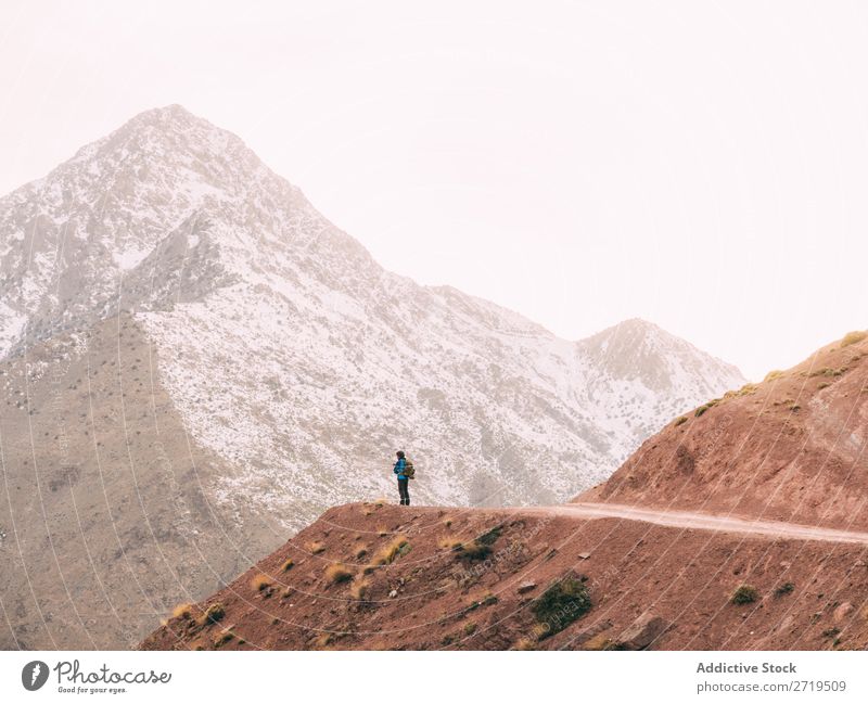 Anonymous person on mountains road Human being Mountain Tourism Landscape Rock Ski-run Lanes & trails Vacation & Travel Nature Panorama (Format) Valley Snow