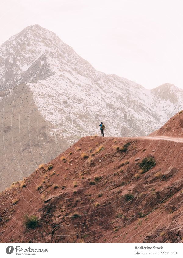 Anonymous person on mountains road Human being Mountain Tourism Landscape Rock Ski-run Lanes & trails Vacation & Travel Nature Panorama (Format) Valley Snow