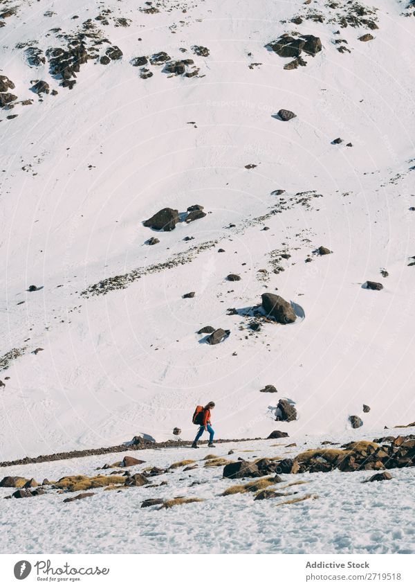 Person walking among snows in mountains Human being Mountain Tourism Winter Landscape Rock Ski-run Snow Lanes & trails Walking Vacation & Travel Nature