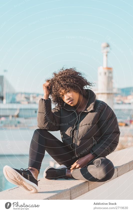 Stylish woman sitting on fence Woman Ethnic pretty Beautiful Youth (Young adults) City Park Sit Fence Style Easygoing Cool (slang) Portrait photograph