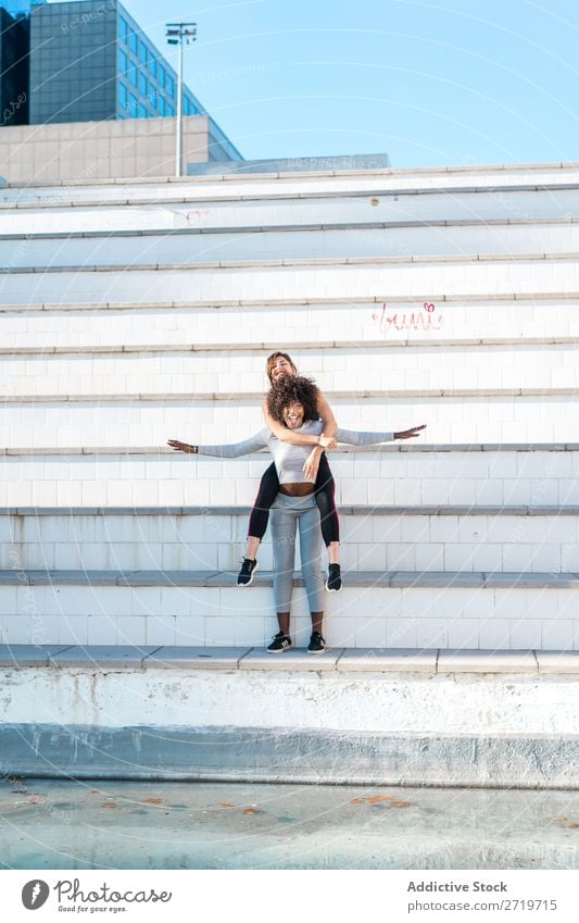 Woman carrying her friend behind her back Athletic Together pretty Youth (Young adults) Cheerful Smiling Steps Jump Stretching Beautiful Sports multiethnic