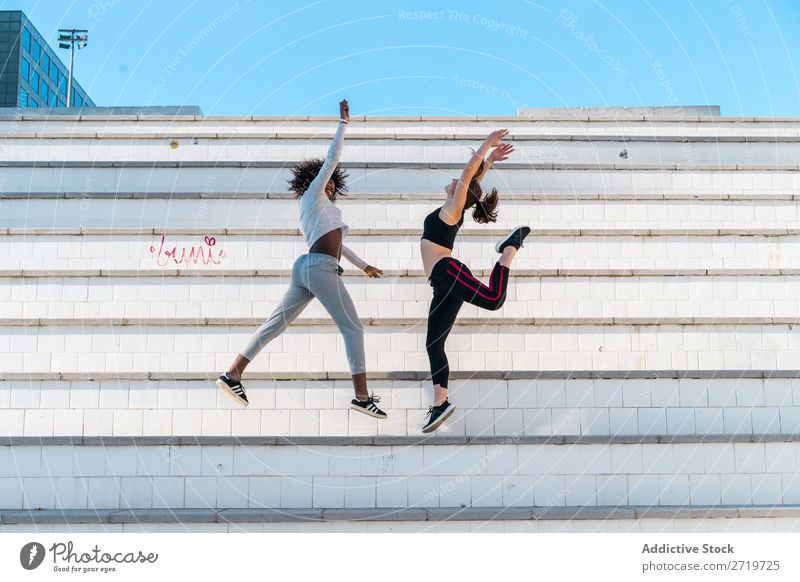 Pretty fit women jumping together Woman Athletic Together pretty Youth (Young adults) Cheerful Smiling Steps Jump Stretching Beautiful Sports multiethnic