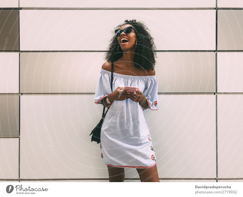 Cheerful black woman with mobile phone Woman Wall (building) Adults Easygoing PDA African Ethnic Cellphone Copy Space Youth (Young adults) Lifestyle pastel