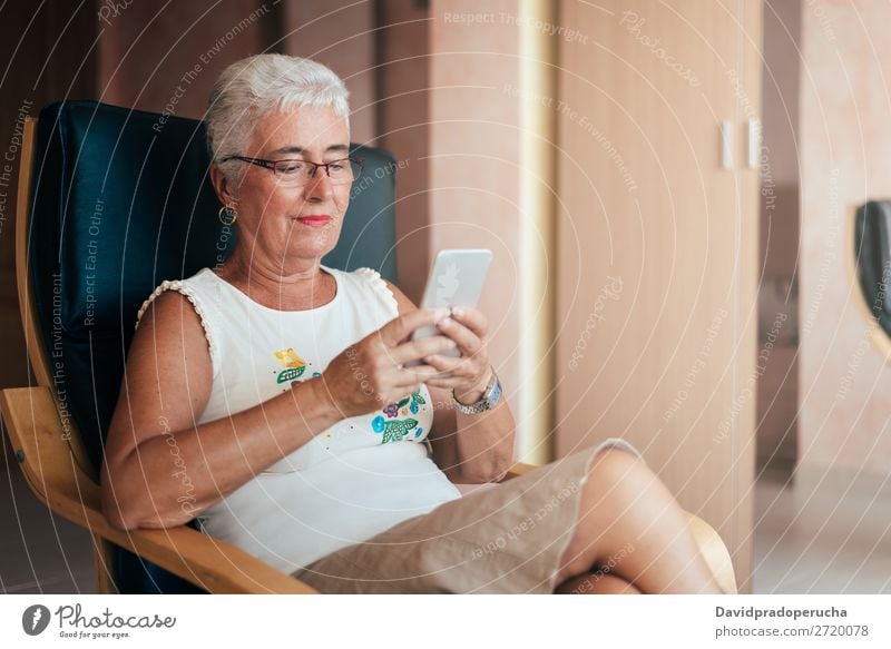 Elderly woman on the mobile phone at home Woman grey hair Cellphone PDA Old Home Communication retired Human being Technology Leisure and hobbies Sit