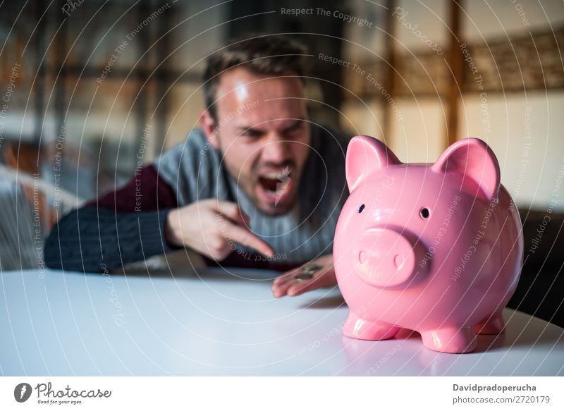 Unhappy man angry at his piggy bank Man Money box savings Crisis Sadness Anger Stress Emotions annoyed Scream trouble Expression frustrated Problem shouting