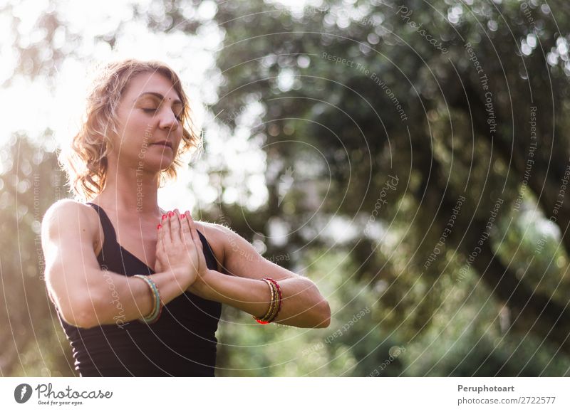 Beautiful young woman meditates in yoga asana Padmasana - Lotus pose on the wooden deck in the autumn park. Lifestyle Wellness Relaxation Meditation Yoga