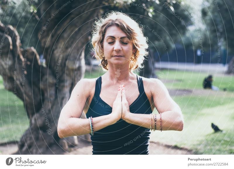 Young woman meditates in yoga asana Padmasana - Lotus pose Lifestyle Wellness Relaxation Meditation Yoga Human being Woman Adults Nature Autumn Leaf Park Wood