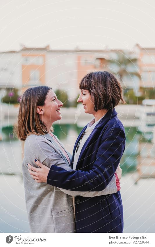 Two happy friends or sisters hugging on the street Lifestyle Joy Happy Sun Meeting To talk Homosexual Woman Adults Family & Relations Friendship Group Street