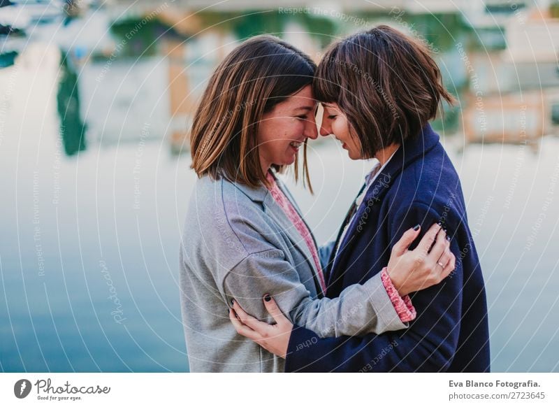 Two happy friends or sisters hugging on the street. Lifestyle Joy Happy Sun Meeting To talk Homosexual Woman Adults Family & Relations Friendship Group Street