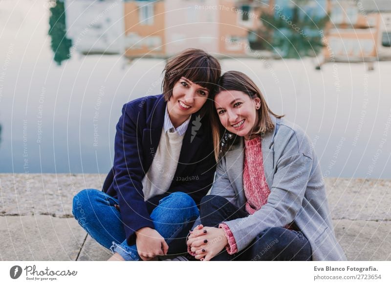 Two happy friends or sisters sitting outdoors Lifestyle Joy Happy Sun Meeting To talk Homosexual Woman Adults Family & Relations Friendship Group Street Smiling