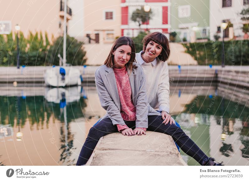 Two happy friends or sisters sitting on the floor Lifestyle Joy Happy Sun Meeting To talk Homosexual Woman Adults Family & Relations Friendship Group Street