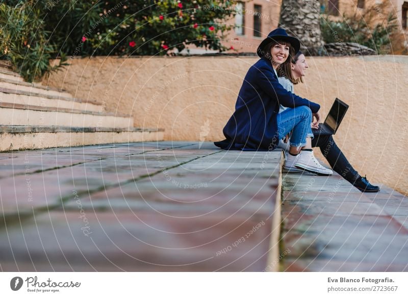 two women friends sitting down at stairs outdoors using laptop Happy Beautiful Relaxation Vacation & Travel Sun Academic studies Work and employment Computer