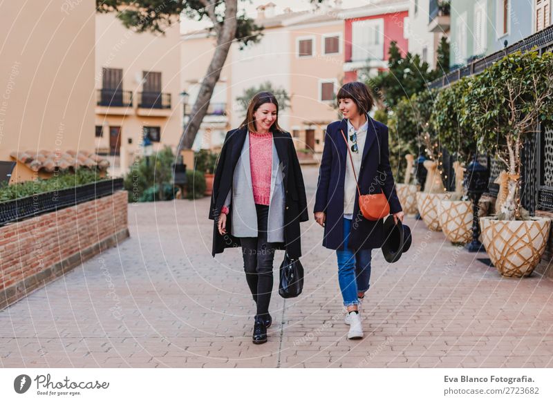 Two happy friends walking by the street. Lifestyle Joy Happy Sun Meeting To talk Woman Adults Family & Relations Friendship Group Street Smiling Laughter Good