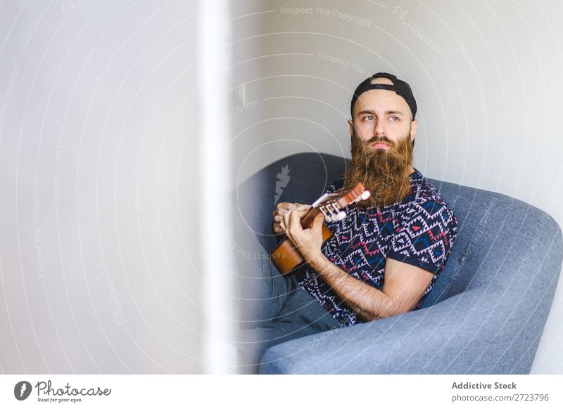 Man playing guitar in armchair Home Relaxation Adults bearded Sit Armchair Playing Guitar Musician Acoustic Easygoing Youth (Young adults)