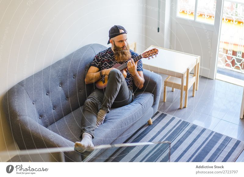 Man playing guitar in armchair Home Relaxation Adults bearded Sit Armchair Playing Guitar Musician Acoustic Easygoing Youth (Young adults)