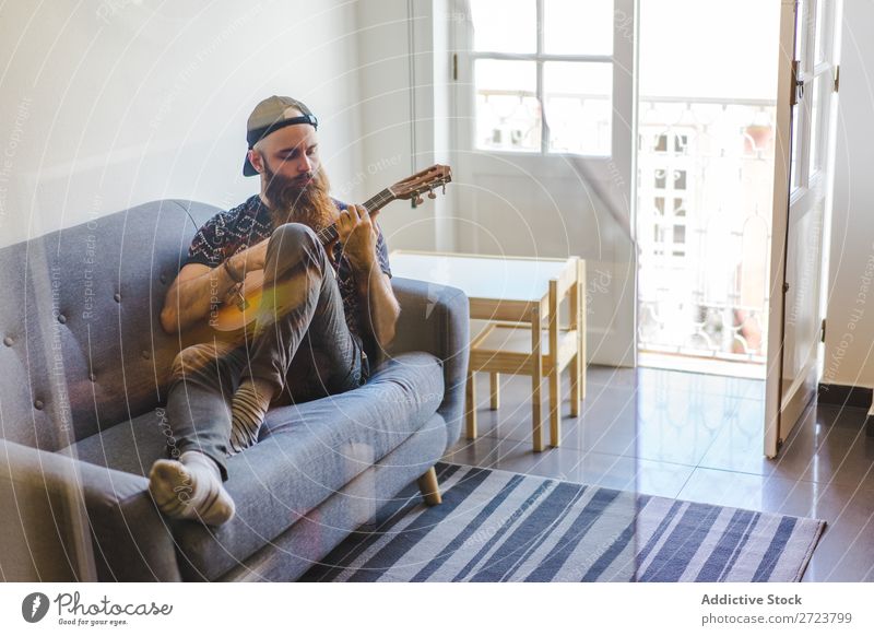 Man playing guitar in armchair Home Relaxation Adults bearded Sit Armchair Playing Guitar Musician Acoustic Easygoing Youth (Young adults)