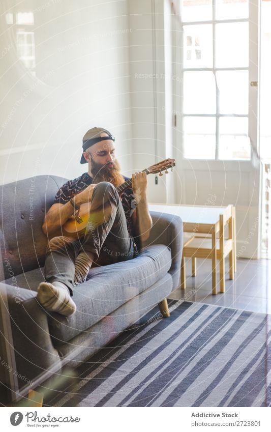 Man playing guitar in armchair Home Relaxation Adults bearded Sit Armchair Playing Guitar Musician Acoustic Easygoing Youth (Young adults)