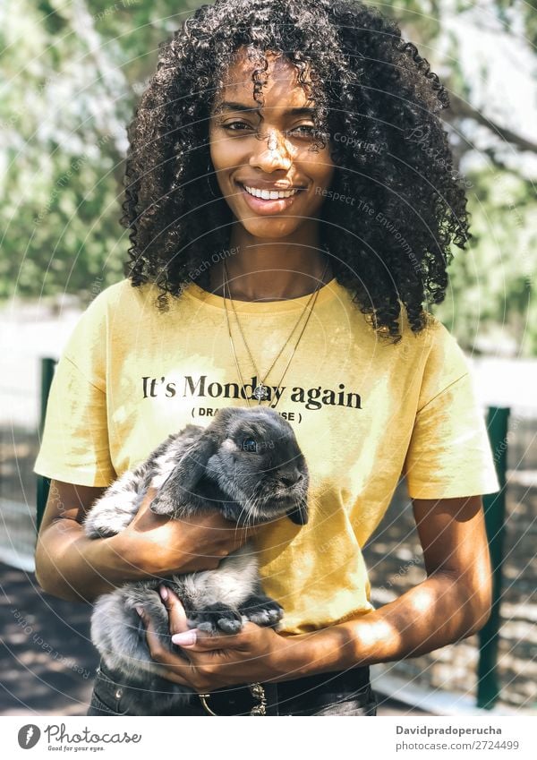 Black woman holding a cute bunny Woman Ethnic Pet Hare & Rabbit & Bunny Fluffy Love Cute Animal Fur coat Ear Domestic Delightful African Cheerful Smiling Summer