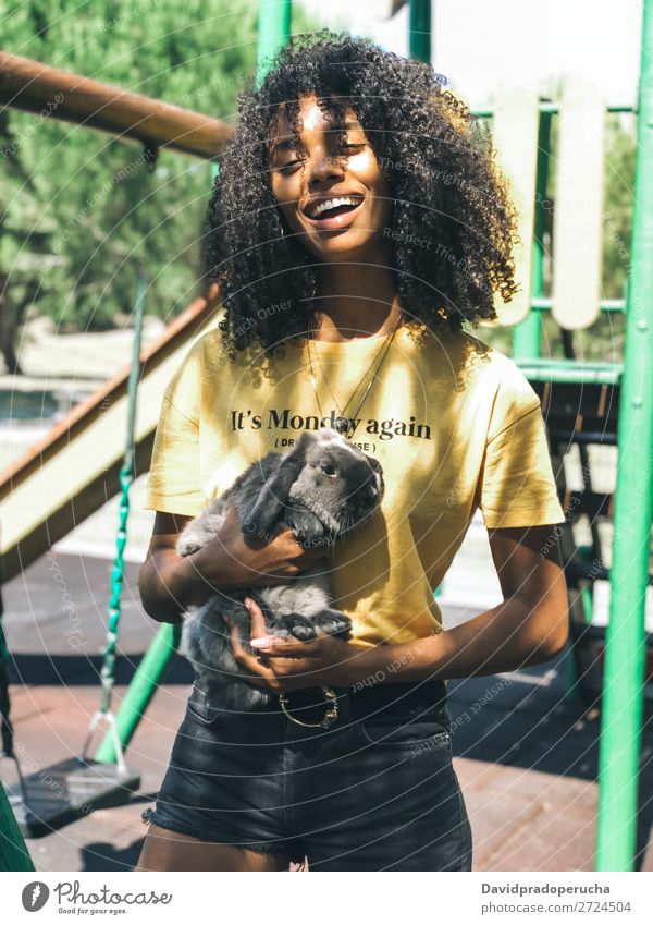 Black woman holding a cute bunny Woman Ethnic Pet Hare & Rabbit & Bunny Fluffy Love Cute Animal Fur coat Ear Domestic Delightful African Cheerful Smiling Summer