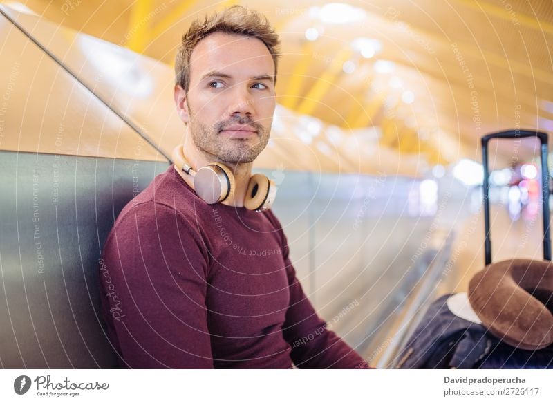 Young man waiting listening music and using mobile phone at the airport with a suitcase. Wait Airport Youth (Young adults) Smiling Caucasian Listening Music