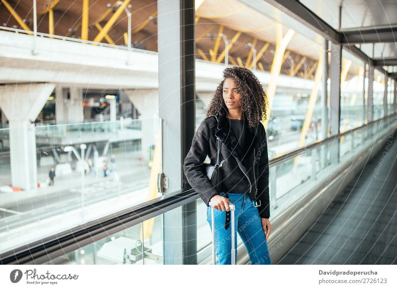 black woman in the moving walkway at the airport with a pink suitcase. Woman Beautiful African American Movement Corridor Escalator Trip Airport Station Luggage