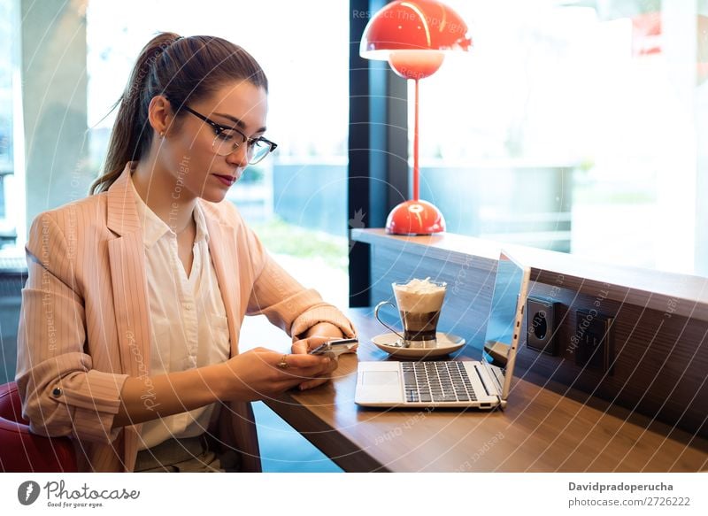 Young beautiful woman with laptop , smartphone and coffee in a Restaurant Woman Notebook Telephone Mobile PDA Youth (Young adults) Businesswoman Coffee Smiling