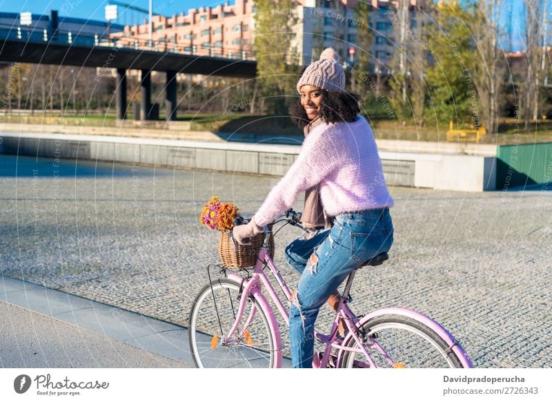 Black young woman riding a vintage bicycle Bicycle Vintage Basket Girl Woman Mixed race ethnicity Beautiful Retro Flower Happy Bouquet Winter Autumn