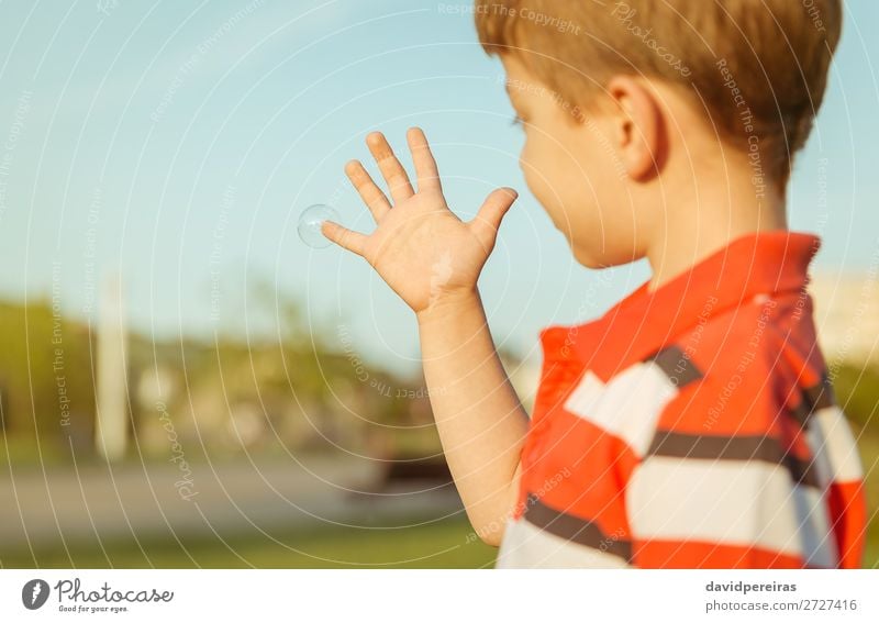 Cute boy looking soap bubble in his open hand Lifestyle Joy Happy Beautiful Relaxation Leisure and hobbies Playing Freedom Summer Garden Child Human being