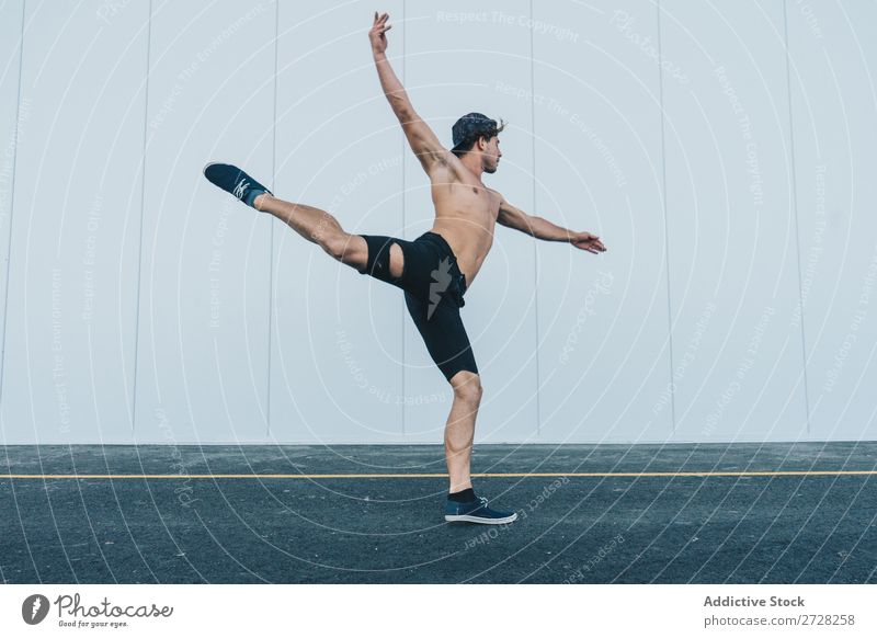 Sportive man dancing at street Man Dancer Posture Town Hipster Elegant Athletic Performance Street Balance Muscular leg up Movement workout City Hands up!