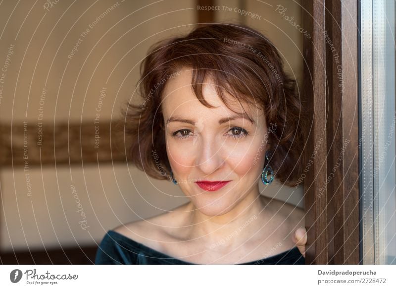 Portrait of a mature woman posing thoughtful throughout the window Portrait photograph Woman Red-haired Mature Old Human being Window Considerate Stand