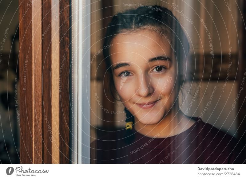 Portrait of a young teenager girl standing looking throughout the window Girl Youth (Young adults) Portrait photograph Child Isolated Loneliness Face