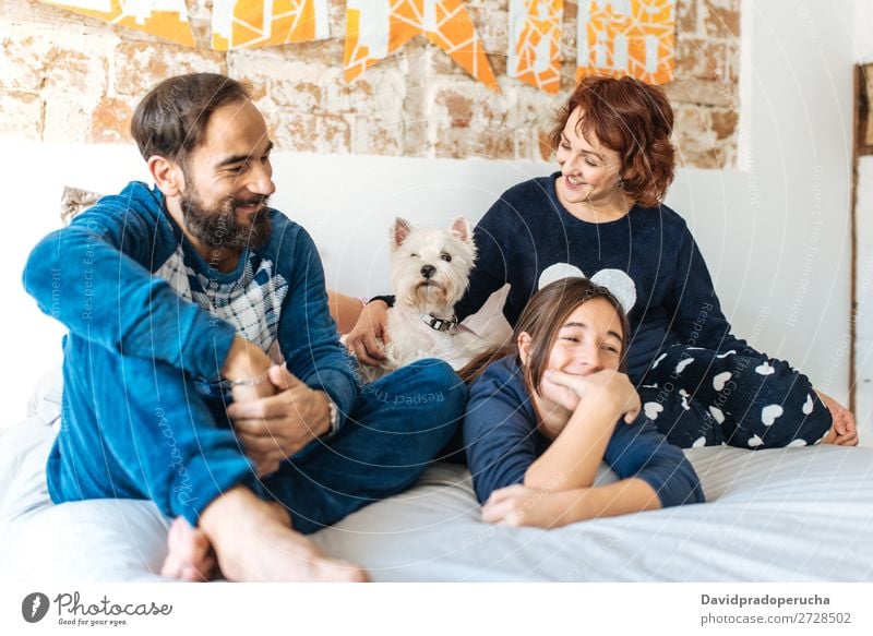 Couple relaxed at home in bed with their little daughter and the dog Affection Bed Bedroom Wife Husband Daughter Child Small Dog Pet Puppy mum dad Parents