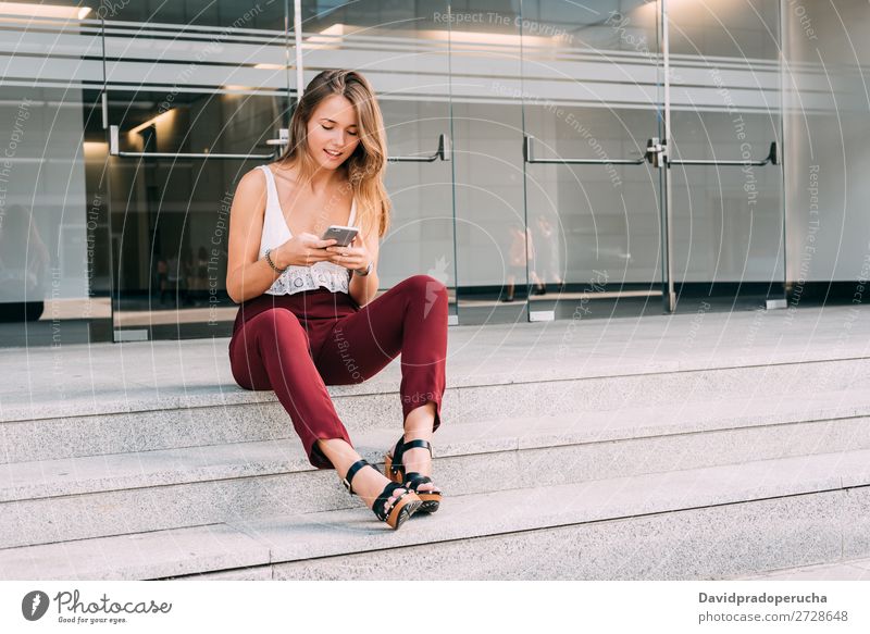 Beautiful young woman sitting in the stairs on the mobile phone Woman Blonde Telephone Mobile Technology Sit Stairs Exterior shot sits Youth (Young adults)