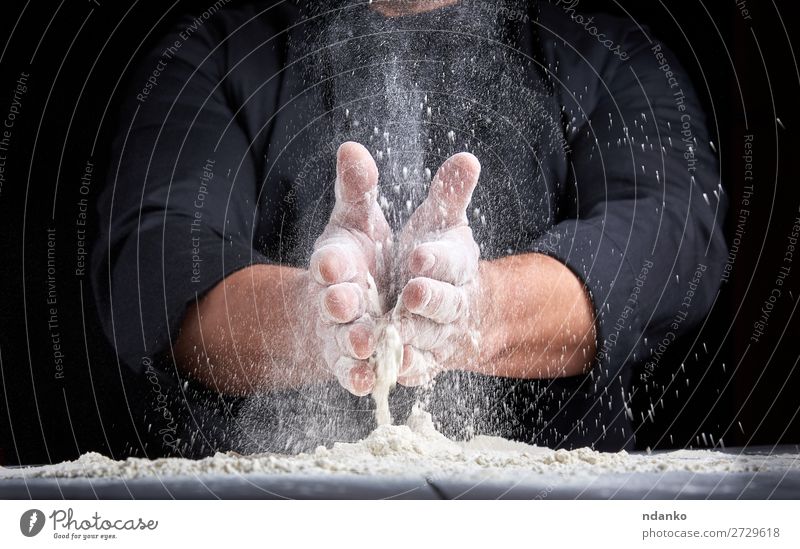 chef in black uniform pours white wheat flour Dough Baked goods Bread Table Kitchen Work and employment Cook Human being Man Adults Hand Wood Make Dark Black