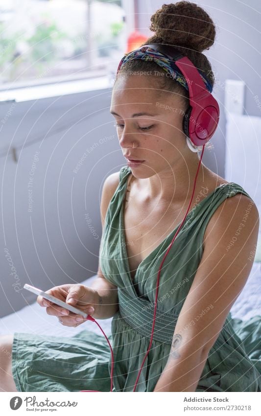 Woman using phone and headphones on bed Bed Relaxation Headphones To enjoy PDA Home browsing Entertainment Recklessness Listening Cheerful Internet Wireless