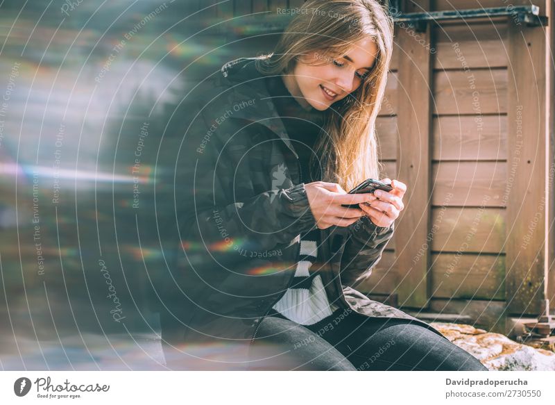 portrait Young beautiful woman in winter in the snow using mobile phone Portrait photograph Winter Woman Snow Mobile Telephone Cellphone Wood Rural log cabin